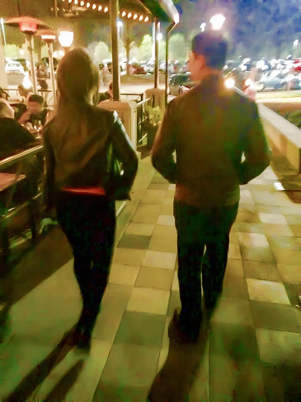 Roberto Pinto y una amiga caminando de espaldas por una vereda de Atlanta de noche